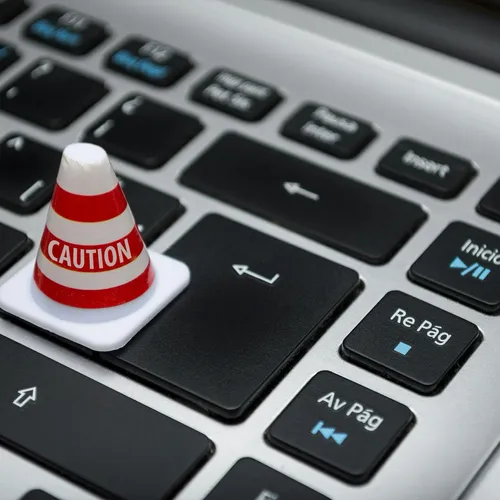 A caution cone on a keyboard key — minimal scopes, granted with care