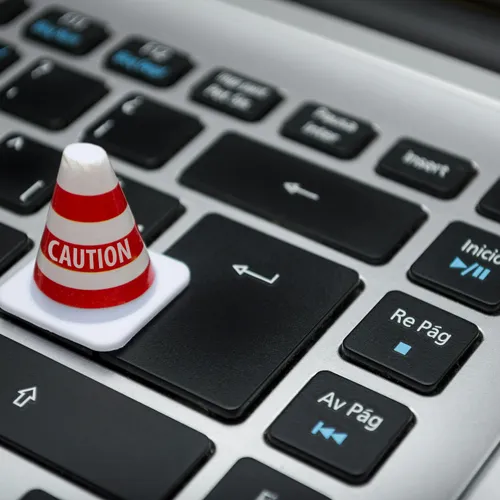 A caution cone on a keyboard key — minimal scopes, granted with care